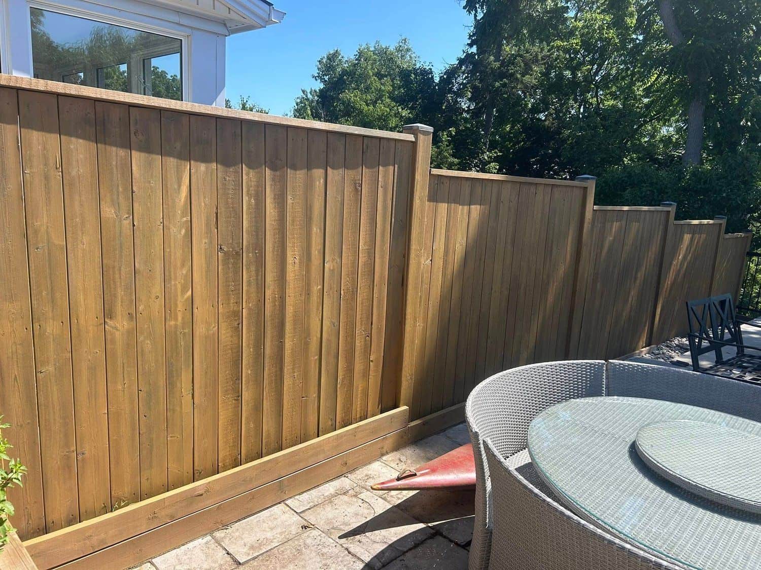 New wood privacy fence beside a paver patio